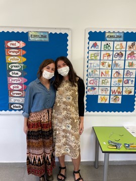 Hackman and friend pose in front of classroom. 